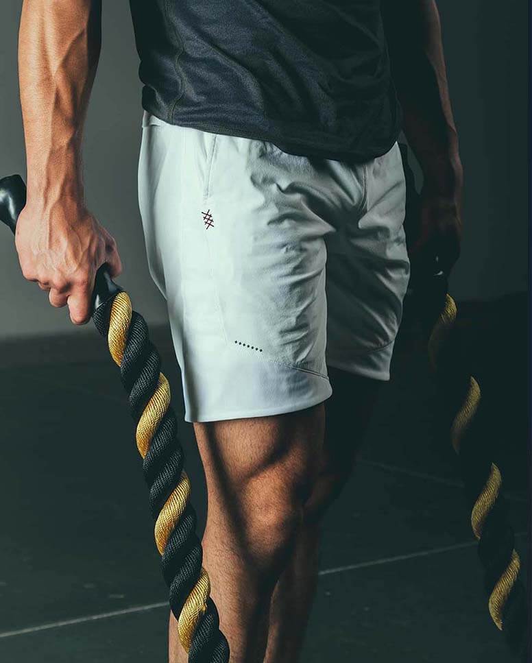 A man holds workout ropes.